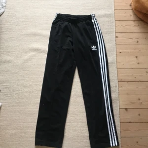Adidasbyxor  - Svarta Adidasbyxor, köpta på plick men har inte använt så mycket. Använt men fint skick. Dragkedja nere vid fötterna.