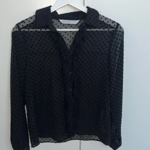 Svart lite genomskinlig blus  - Säljer denna super fina blus som jag inte fått till användning för har it vetat när jag ska använda den och säljer därför. Den är i väldigt bra skicka och är en super gammal model så den finns it kvar. Blusen är lite genomskinlig. 