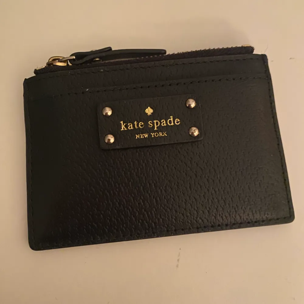 Kate Spade skinn korthållare i fint skick, knappt använd, i svart, har ett fack med dragkedja och tre frack för kort. . Asusteet.