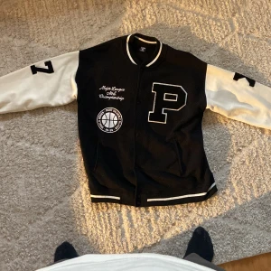 BlacknWhite varsity jacket - A relaxed fit, black n white varsity jacket in size XL. The fabric is soft and all the details are sown in. The jacket is thick and warm. I have never used it.