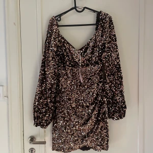 Festklänning perfekt för nyår!  - Paljettklänning i storlek 38 från Nelly. Den har brun/guldiga paljetter, är i omlott både över brösten och vid benen. Jag trodde att det var längre returtid på Nellys hemsida och det var fel storlek på mig! Nypris 799💕(slutsåld på Nelly)