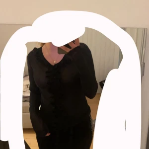 Fest tröja - En svart fest tröja som är rätt genomskinlig med volanger , strl XS/S , vet ej märke 