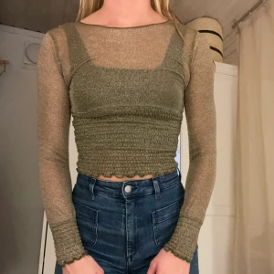 Festtopp - En långärmad glittrig grön/guld topp från Na-KD (dock köpt här på Plick). Perfekt skick!