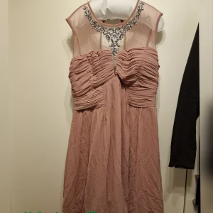 Finklänning - Använd en gång. Står 52 som storlek men passar både mindre och större. Är elastisk och ribbad i ryggen. Skön, följsam, lätt och smickrande för oss som inte vill ha det tight. Kan skicka fler bilder vid behov