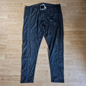 Byxor Adia Fashion strl 50 - Oanvända byxor med lapparna kvar från Adia Fashion, storlek 50. Ganska tunna, tighta. Ormskinns-look.