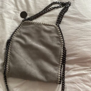 stella McCartney väska - så fin väska i jätte bra skick😍 knappt använd😍 Den är ganska liten och grå och har 3 olika kedjor❤️KÖP DIREKT FÖR 420 + frakt