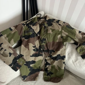 Camouflagejacka i storlek XS/S - Armyjacka/ militärjacka i storlek XS/S. Jag har storlek XS i kläder. Mycket fint skick men en knapp saknas, påverkar inte användning, syns ej! Köparen står för frakt på 66kr spårbart, annars möts jag upp i centrala Göteborg. 
