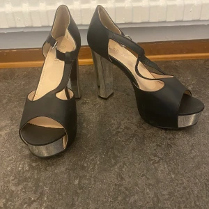 Klackar  - Klackskor i färgen svart med silver klack. Mycket bra skick 