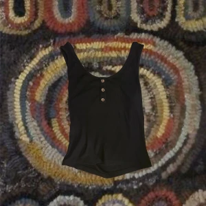 Svart tanktop - Svart tank topp med knappar!! Väldigt mjukt material och är i väldigt bra skick :) som ny! 