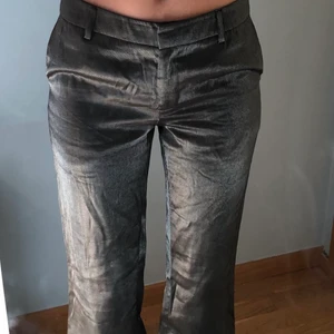 Kostymbyxor  - Ett par lågmidjade flared kostymbyxor! Lite skimrig grå aktig färg! Passar mig som är en 34 ish i storlek och lite väl långa, är 165-168, passar nog bättre på någon som är 175 ish!