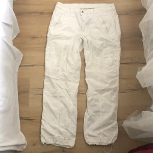 Vita cargo pants strl 46 - I bra skick med två små fläckar på framsida ben. Från H&M B.B, en gammal H&M kollektion. Midjemått på 96cm och innerbenslängd på 76cm. Köparen står för frakt.