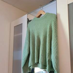 En grön stickad tröja från h&m i storlek M