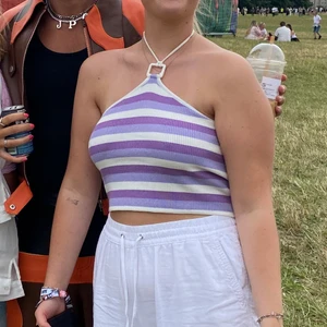 Randig topp  - En jättefin randig lila topp med knyt i nacken, den är lite öppen i ryggen men tröjan går fortfarande hela vägen runt till ryggen.   Säljer pga lite stor.