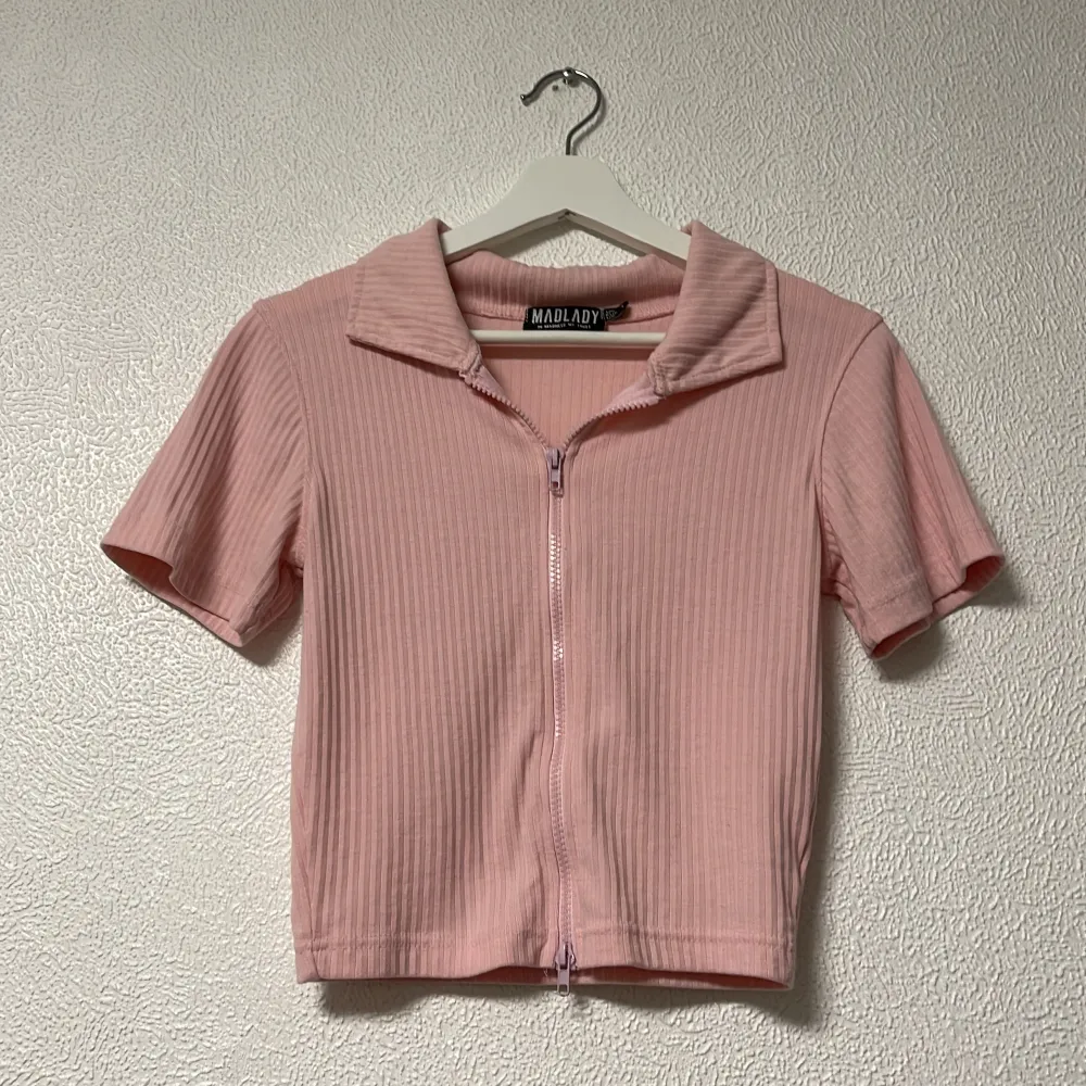 Säljer denna söta rosa piké toppen i stl S som har en justerbar dragkedja framtill. Köpt från madlady för 249 kr. Frakten ingår ej i priset. . Yläosat.