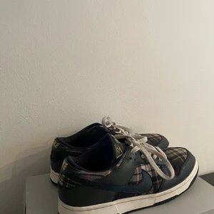 Vintage Nike dunk low tartan/plaid 2003 - Säljer nu mina låga dunks då de ej passar längre. Superbra skick för att vara 20 år gamla, ända skadan är fram på sulan som man kan se på bild 2, därav de billiga priset. Strlk 44,5 (mer 43,5-44)