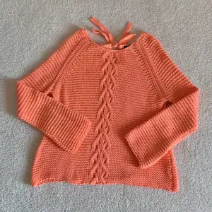 Magiskt fin stickad tröja från Lindex i en orange/korallfärgad nyans 🪸 Vida ärmar och knyts med rosett i ryggen. Köpt för många år sedan. Fint skick, inga noppror men något pyttelite mörkare nyans vid ärmslut. Sitter snyggt OZ på mig som är XS/S.