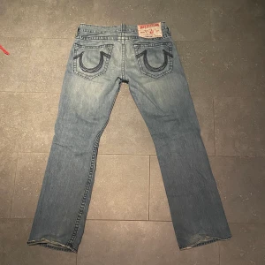 True Religion Jeans - Feta Trueys säljs pga att de inte längre används. Väldigt bra skick minus ett mindre hål på framsidan (syns på en av bilderna) som med största sannolikhet går att sy ihop. Storlek W33 L34, skulle säga att de passar dig som är 180-187 ungefär!