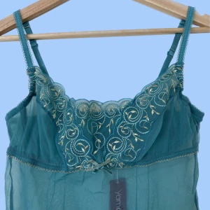 Blått meshlinne - Blått meshlinne med blå och gröna spetsdetaljer. Det har juserbara axelband och kupor med byglar. Storleken 70B eller S/M. Helt oanvänt, lapp kvar, så mycket bra skick. Hör av dig om du har frågor:)