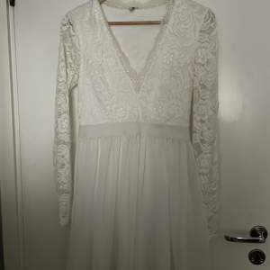 En vit klänning v ringning och med spetsärmar och ger en fina former. Använd 2/3 gånger. 