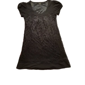 Klänning  - Svart kort klänning med fina spets blommor. Den är i stolek XS och är super bekväm då insidan är i siden