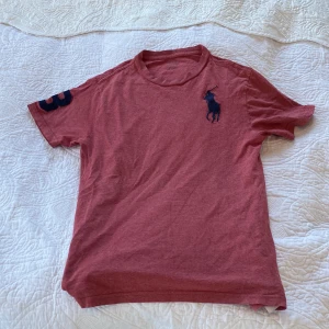 POLO RALPH LAUREN  - En, röd-rosa t-shirt med ett ganska stor RALPH LAUREN tryck 