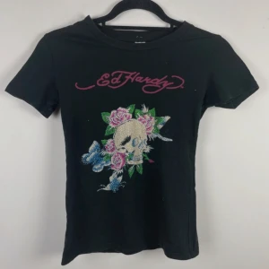 Ed Hardy tröja - såå fin ed hardy baby tee, superbra skick och har i princip alla stenar kvar!! står storlek M men sitter som en XS skulle jag säga!! säljes pga lite för liten för mig :(