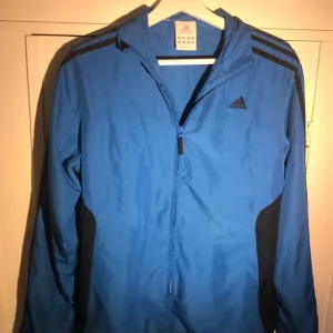 Adidas jacka jacket track vindjacka - Cool jacka! Förutom att det syns lite skrivet ett namn i storleks taggen. Storlek står L usa , 13-14 UK , 164 EU. Det är ”killstorlek” och skulle nog säga att det motsvarar medium i ”tjejstorlek.”