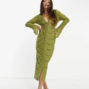 Olivgrön klänning i skjortmodell med utskurna detaljer. Aldrig använd, prislapp är kvar. 