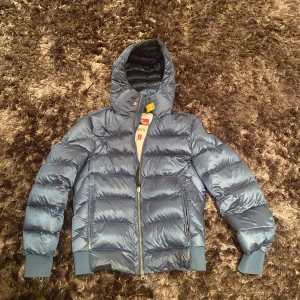 Parajumpers pharrel sheen jacka.  - Jackan är köpt på Care of Carl. Den är i nyskick och har inga skador.   i färgen petrol.    Länk https://www.careofcarl.se/sv/artiklar/parajumpers-pharrell-sheen-high-gloss-jacket-agave.html?channable=041410696400323333323839313338&gclid=Cj0KCQiAveebBhD_A
