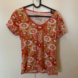 Tshirt i 70-talsstil - Häftig blommig tshirt i 70-talsstil. Storlek L men något mindre i passformen