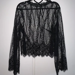 Mesch blus med vida ärmar  - Svart spetsig blus med vida ärmar från H&M i storlek 40, mer än 36/38. 