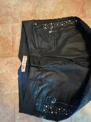 Fräsiga brallor - Mycket gott skick, sparsamt använda. Skinnliknande look. Stl 42