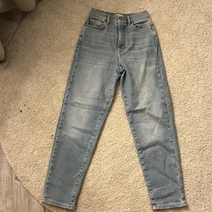 Blåa Comfy mom jeans - Ett par blåa comfy mom jeans från ginatricot som är använda max 3 gånger. Köpte de för 499 kr för ett år sen. Säljer för att jag inte använder de längre. Stl 34 men skulle säga att de är mindre men stretchiga.(3dje bilden är samma fast de är blåa.