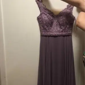 Det är en jätte fin lång lila balklänning som är glittrig vid överkroppen. Klänningen använd en gång. Den är i en väldigt bra skick. Väldigt ren. Jag har köpt den för 2500kr. 