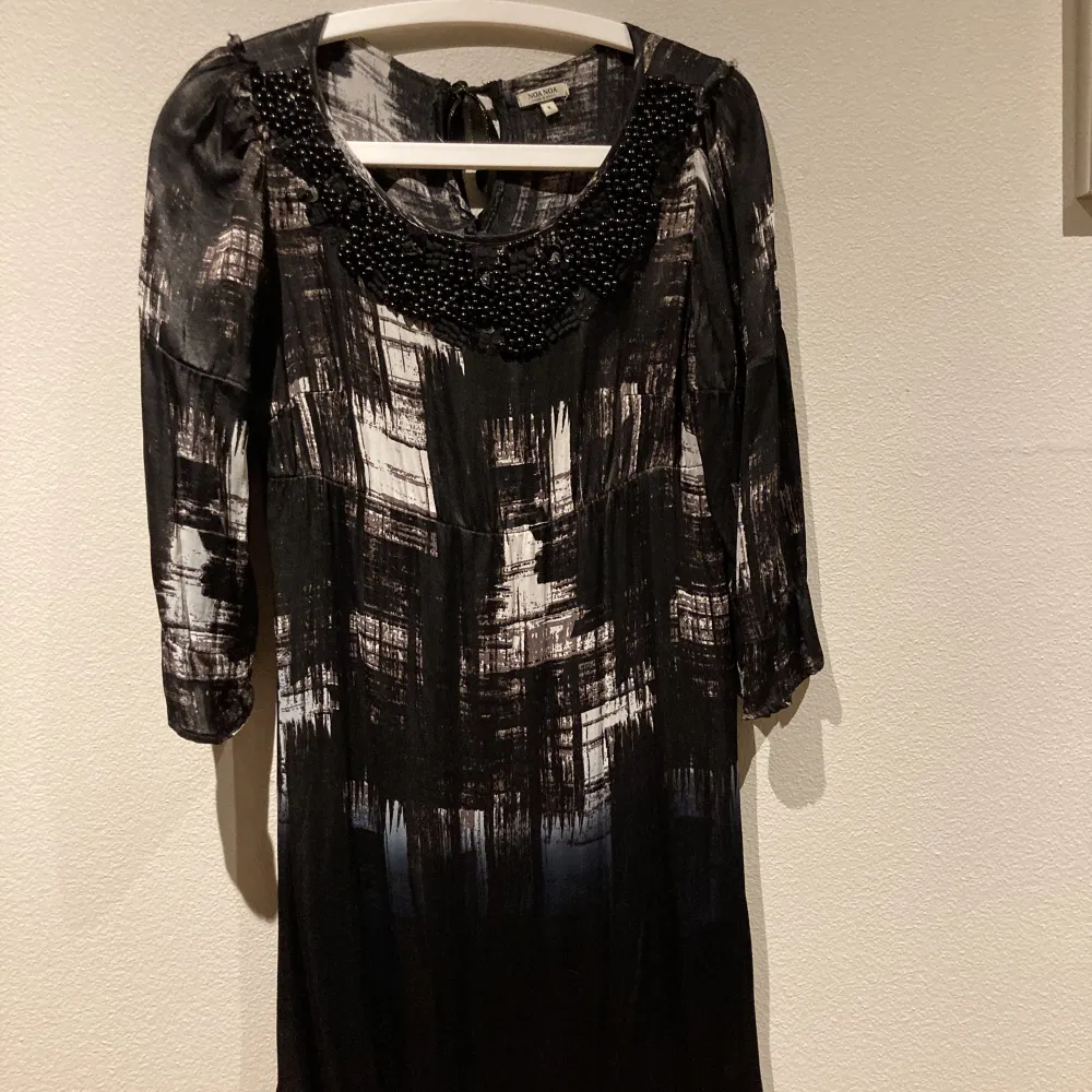 En svartvit klänning från Noa Noa med broderade pärlor upptill. Klänningen är i storlek i small med lös passform. Materialet består av 100% viskos.. Klänningar.