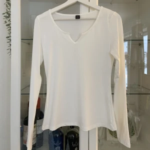 Långärmad  - Vit långärmad med litet V. Aldrig använd.