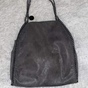 En fejk Stella McCartney liknade väska som är grå och har ett fint skimmer och är i storlek medium!