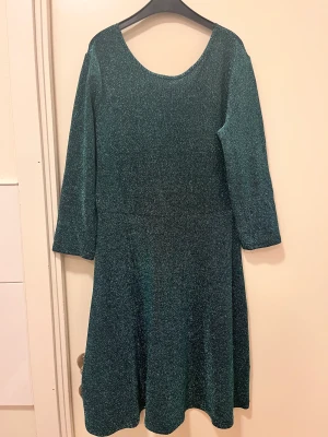 Klänning - Glittrig grön klänning från Cubus. Säljs eftersom den inte längre kommer till användning.