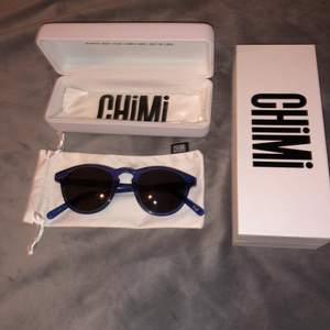 Chimi solglasögon. Färgen Acai (mörkblåa), svart glas. I modellen 002. Fint skick med all tillbehör förutom påsen.