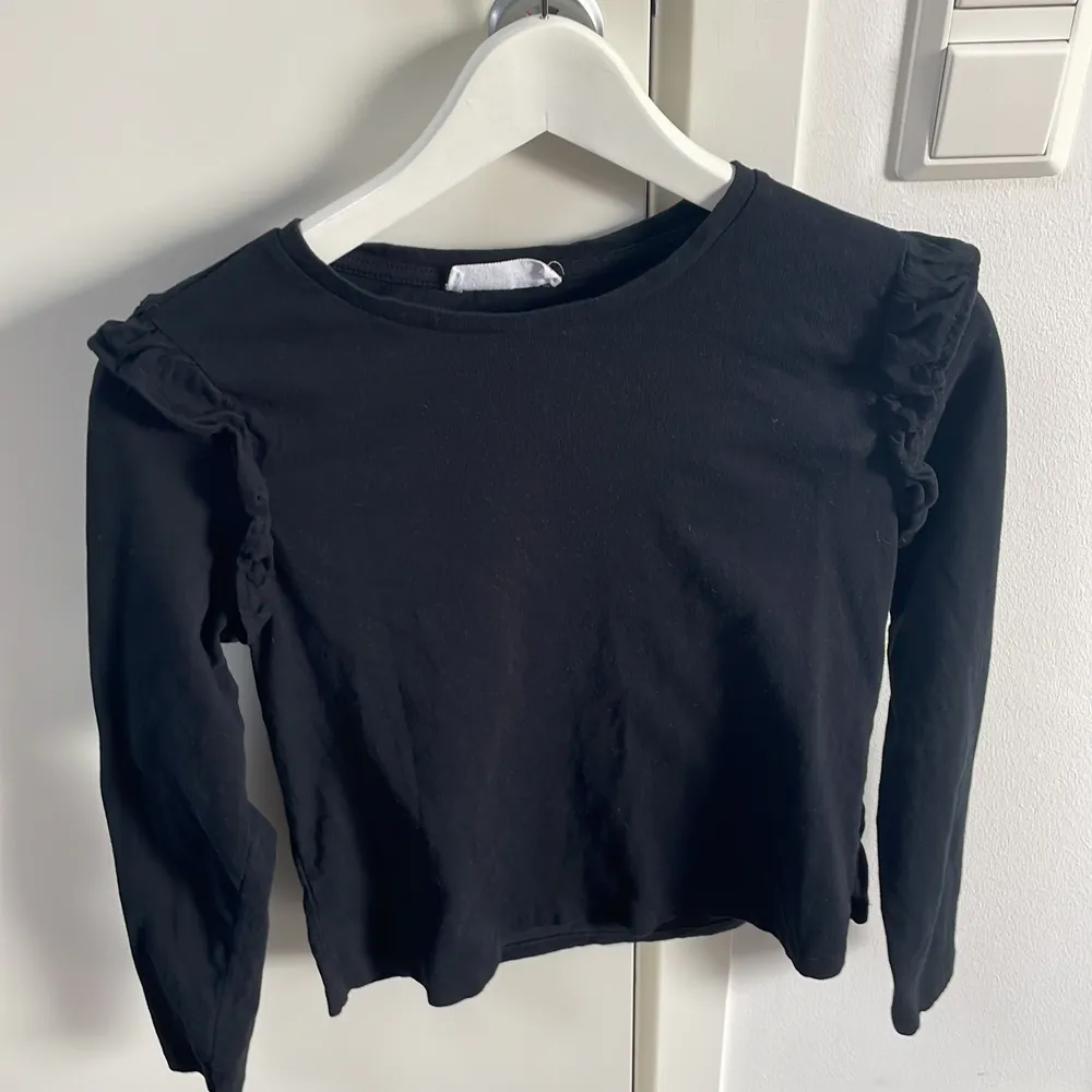 En fin svart långärmad tröja med små volanger på axlarna, har använt en gång men säljer då det inte är min stil. Köparen står för fraktkostnaden . Tröjor & Koftor.