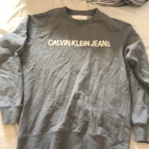 Calvin Klein jeans sweatshirt  - Jag säljer en grå Calvin Klein jeans sweatshirt eftersom jag helt enkelt inte vill använda den längre. Absoulut inga fel med den och har inte heller använt den för många gånger, ca 3,4. Jag har dock inte kvittot kvar då jag har slängt det. Nypris 450 säljer för 250