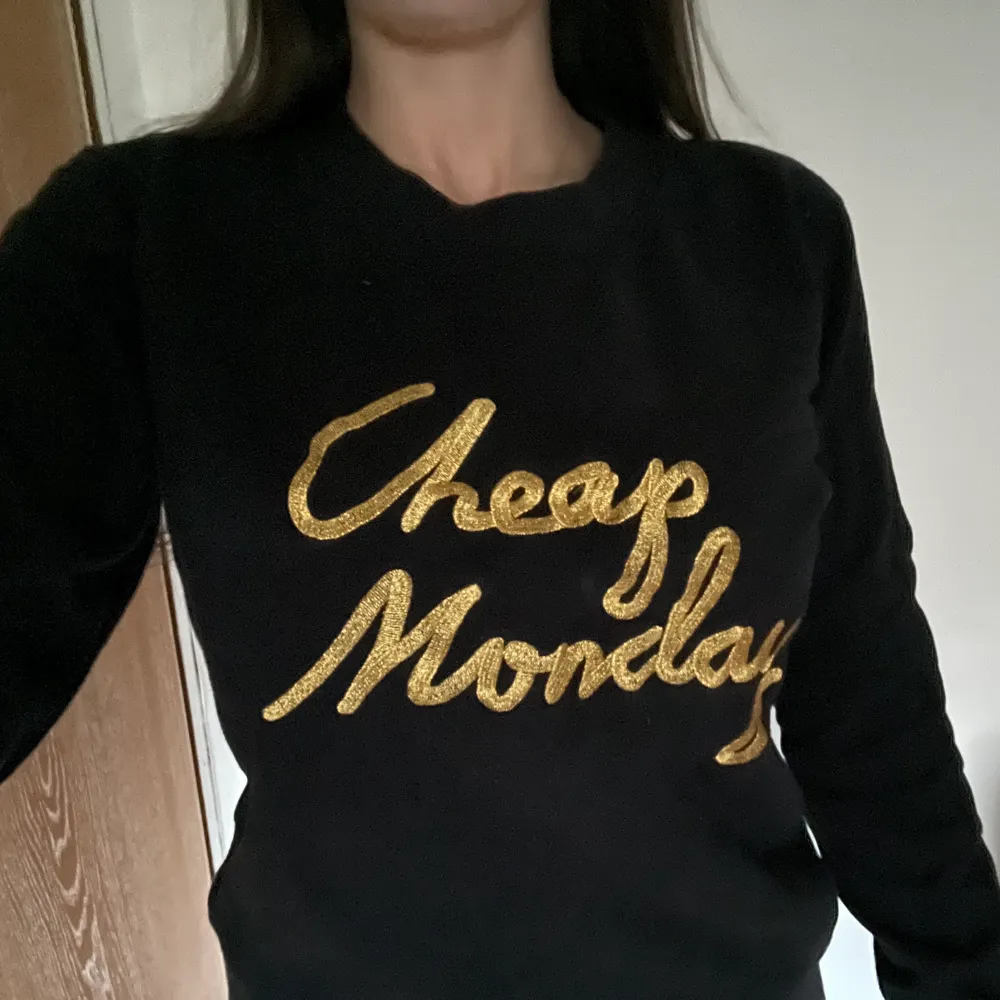 Svart Cheap Monday college tröja med guldigt tryck fram. Använd men bra skicka . Tröjor & Koftor.