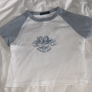 Brandy Melville topp  - Vit och ljusblå topp från Brandy Melville. Den heter Bella topp och är köpt från deras hemsida! Perfekt sommar topp och funkar nästan till allt. Mycket bra kvalitet!💕💙