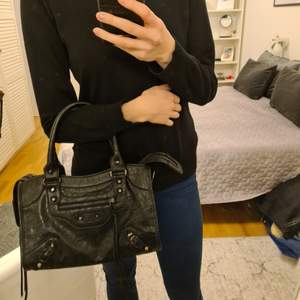 Balenciaga-liknande svart väska, mellanstorlek. Axelband och spegel finns. Ca 30×22.