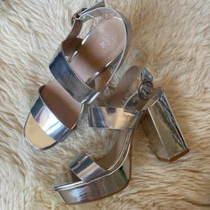 Platåskor H&M - Silvriga platåskor från H&M som används ett fåtal gånger. Lite märken men inget som stör (kolla bilder). Storlek 38