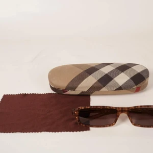 Burberry Solglasögon Unisex  - Varumärke: Burberry Produkt: Solglasögon Material: Plast Skick: Säljs i befintligt, begagnat skick Skador: Bruksslitage, mindre repiga glas Övrigt: Originallåda medföljer.