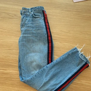 Jeans red side stripe - Jättefina jeans med röda stripes på sidan av benen. Köpte av en kompis så vet ej vart de kommer ifrån men märket är never denim. Säljes pga att de har blivit för små för mig🥰 Bara att skriva om du har frågor:)
