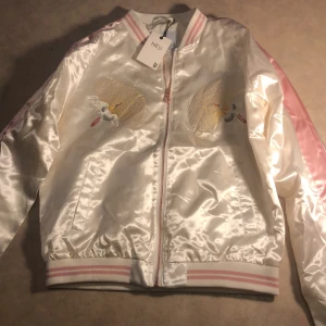 Bomberjacka  - Fortfarande ny i bra skick  Glansig asiatiskt bomberjacka i färgen rosa och vit