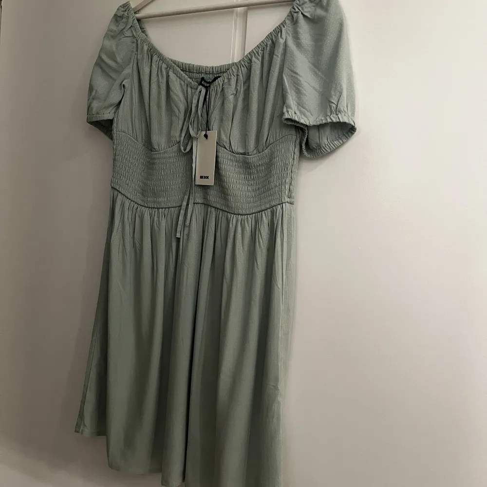 Helt ny mintgrön klänning i korsettstil och puffärmar från BikBok. Säljes pga ångrat köp  Nypris 399kr, prislapp kvar!. Klänningar.