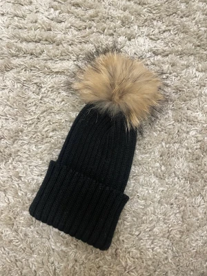 Mössa - Mössa med äkta pälsboll, mycket fint skick. Frakt kostar 57kr spårbart. 